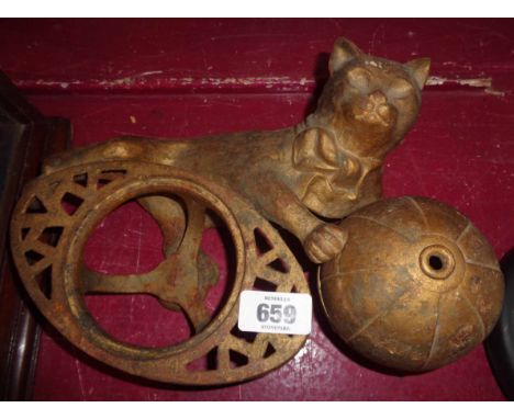 A vintage cast iron string holder in the form of a cat holding a ball with screw top for string and central holder