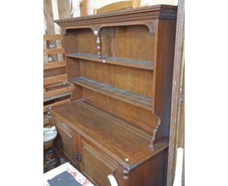 A 5' 20th Century oak two part dresser with central pillar to the two shelf open plate rack over a base enclosed by a pair of