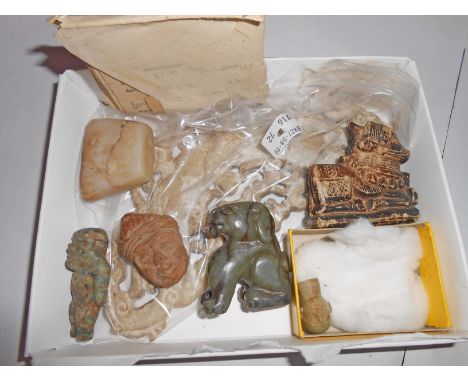 Seven carved objects comprising a jade doll's head, a pre-Columbian green stone figure, a terracotta Babylonian head, jade li