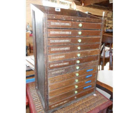 A 14 1/4" vintage stained mixed wood typesetter's chest with flight of twelve partioned drawers and shelf at top