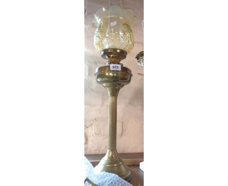 A brass column pattern table oil lamp with amber glass shade