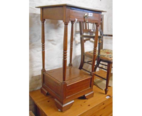 A 15" 20th Century mahogany two tier stand with drawer, turned supports and lift-top compartment under, set on bracket feet