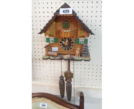 A modern German cuckoo wall clock with twin pine cone pattern weights and certificate of authenticity dated 2006