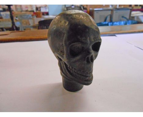 A brass walking stick top in the form of a skull