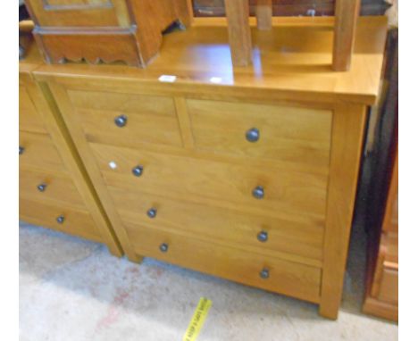 A 35 1/2" polished light oak and mixed wood chest of two short and three long drawers, set on block feet