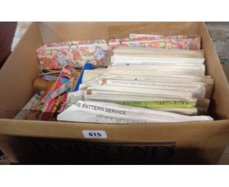 A box containing assorted vintage textiles items including patterns, pinking shears, needles, knitting needles, etc.