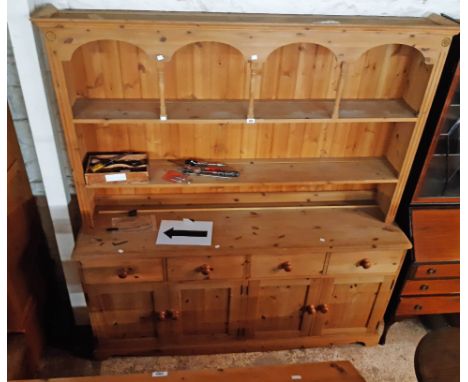 A 6' 1" modern pine two part dresser with arched and spindle decoration to plate rack over a base with four frieze drawers an