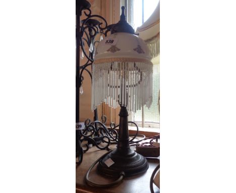 A modern table lamp in the Art Nouveau style with glass shade and beaded fringe