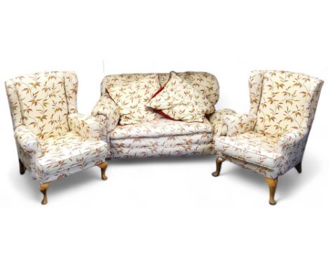 A pair of early 20th century wing back armchairs, cabriole legs, c.1920; a conforming drop arm sofa (3) 