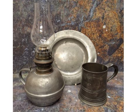 An 18th century pewter oil lamp, globular reservoir, loop handle, 31cm high, c.1780; an 18th century pewter plate, 24cm diam,