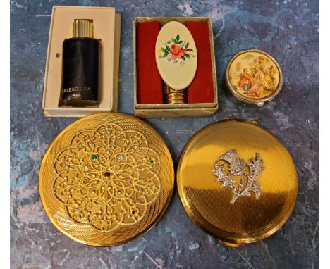 A Kigu compact, the cover mounted with a white thistle set with marcasite; another gilt metal compact, the cover mounted with