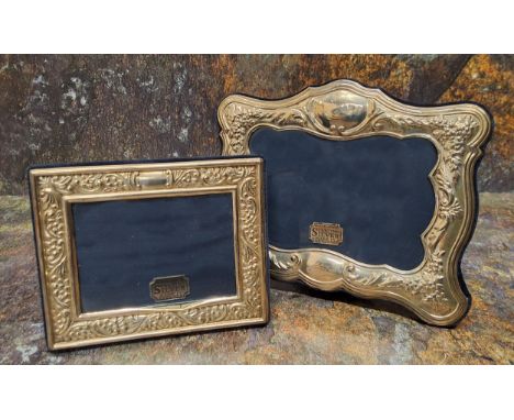 A Victorian style silver shaped rectangular easel photograph frame, embossed with flowers, 14cm x 17cm, Sheffield 1993; anoth