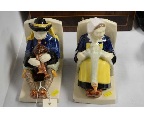 A pair of French Quimper ceramic figural bookends, modelled with a man typing and a lady with a goose, each approximately 18c