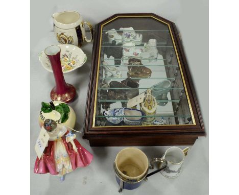 A collection of decorative ceramic shoes, by makers including Hammersley and Spode, contained together in a glazed wall mount