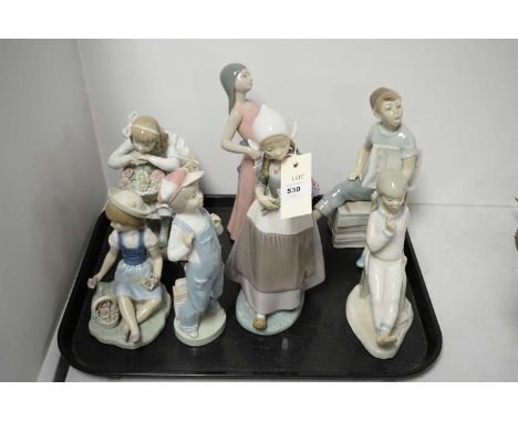 A selection of five Lladro figures of children, the largest a girl holding a bouquet of flowers, 26cms high; together with a 