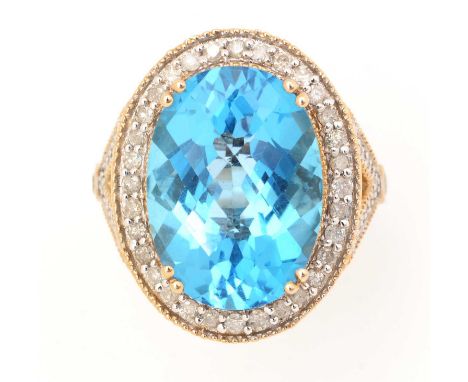 A blue topaz and diamond ring, the oval fancy-facet cut topaz measuring 18.1 x 13.1 x 8.9mm, surrounded by a bezel of brillia