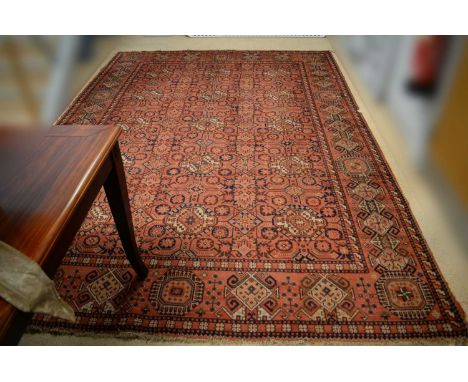 A Turkoman style carpet, with tekke style medallions, in shades of orange and red, 350 x 250cms wide. 