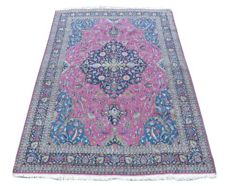 An Isfahan bordered carpet, with central blue floral medallion on a pink foliate ground, 360 x 237cms.