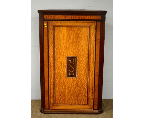 An Edwardian inlaid satinwood corner wall cupboard, the hinged panel door with central rectangular cartouche with mother of p