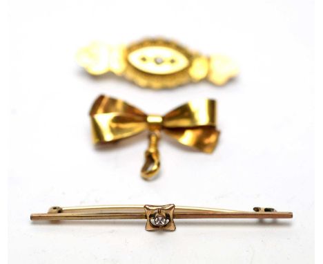 A 9ct yellow gold pearl set brooch; a 9ct gold bow pattern brooch; and a diamond set yellow metal bar brooch.