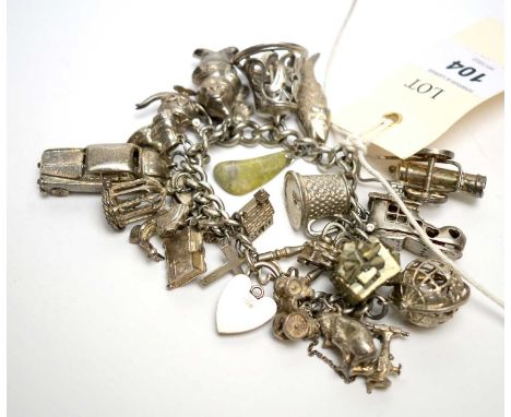 A silver charm bracelet with various silver and white metal charms, including a globe, a Disney Dwarf, and others, 4.4oz.