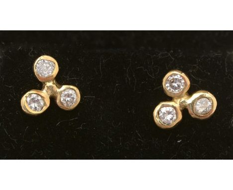 A pair of diamond earrings, each set with three brilliant cut diamonds, estimated to weigh 0.54carats, in 18ct yellow gold mo