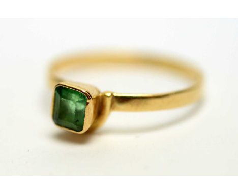 An emerald ring, the square step-cut emerald collet set on yellow metal shank, ring size R, 2.1g gross.