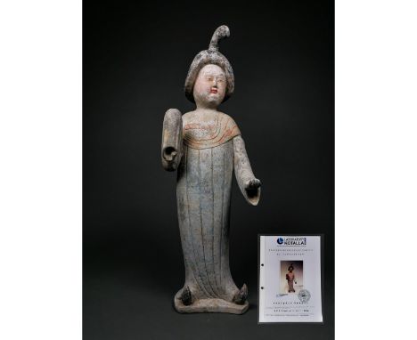 Ca. 618-906 AD; Tang Dynasty. A ceramic figure of a lady in floor-length courtly dress with left hand exposed and right hand 