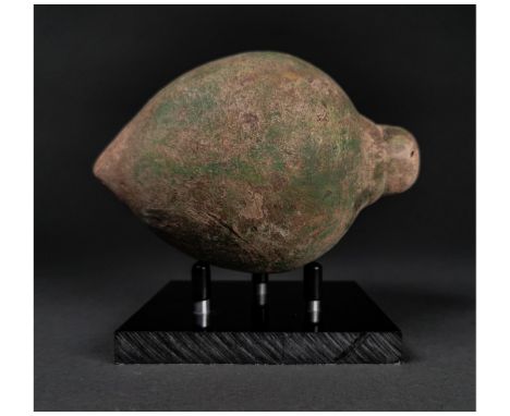 Ca.800 AD. A hollow ceramic Vessel with a barrel-shaped body, domed top, and conical base, knop to the upper face for the mou