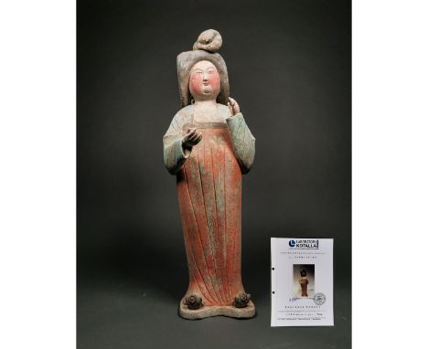 Ca.618-907 AD. A ceramic figure of a female, hair in an elaborate style with top-knot in the form of crescents, hair arranged
