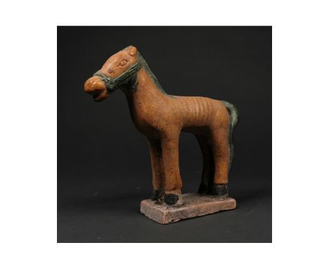 Ca. 1368-1644 AD. Chinese Ming Dynasty glazed terracotta figure of a horse; presented standing in a rectangular base; well pr