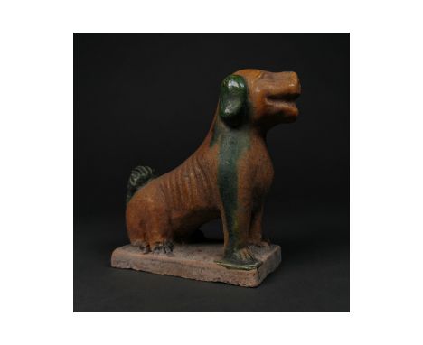 Ca. 1368-1644 AD. Chinese Ming Dynasty glazed terracotta figure of a dog; presented seated on a rectangular base; well preset