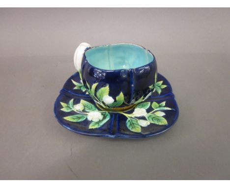 George Jones Majolica cup and saucer decorated in relief with flowers on a cobalt blue ground, together with a small Worceste