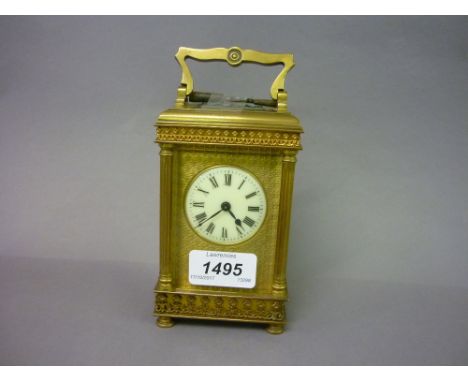 Small late 19th Century ornate brass cased carriage clock with reeded corner pilasters, a circular enamelled dial with Roman 