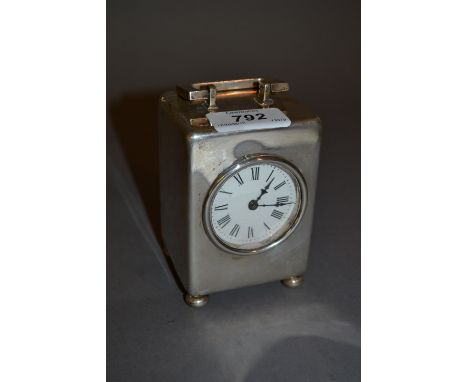 London silver cased carriage clock, the plain case with carrying handle and low bun feet, the circular enamel dial with Roman