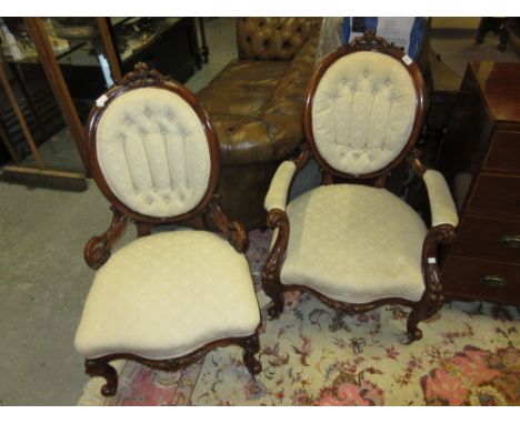 Pair of 19th Century walnut ladies and gentleman's library chairs having button upholstered backs with floral carved decorati