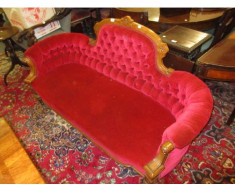 Victorian carved walnut red velvet upholstered sofa with buttoned back raised on turned tapering front supports