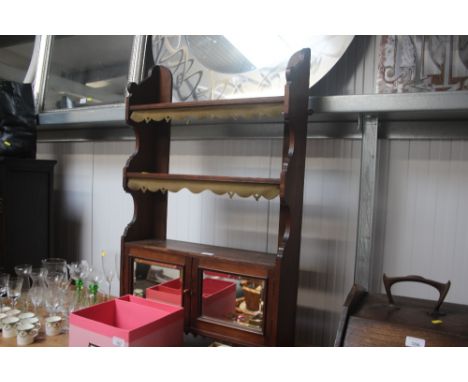 A mahogany and mirror fronted hanging shelf