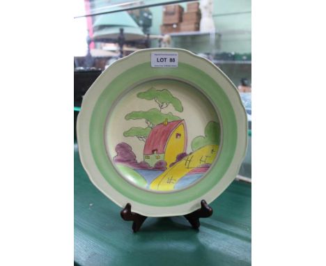 A CLARICE CLIFF FANTASQUE BIZARRE DESIGN&nbsp;HAND-PAINTED PLATE depicting a red roofed house