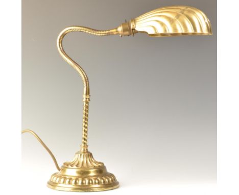 A good early 20th century, circa 1920's gilt metal bankers shell lamp with angular goose neck, half clam shade and circular s
