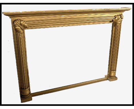 A large 19th century overmantel mirror of giltwood construction having a large ribbed cushion gilt mirrror frame with columns