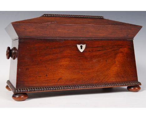 A 19th Century Victorian Rosewood tea caddy of sarcophagus form raised on bun feet with ring turned handles. Hinged lid openi