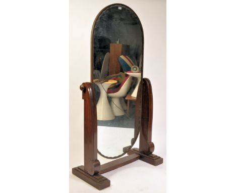 A large 1930's Art Deco mahogany and brass bound cheval dressing mirror. Raised on a stepped mahogany base with shaped tall s