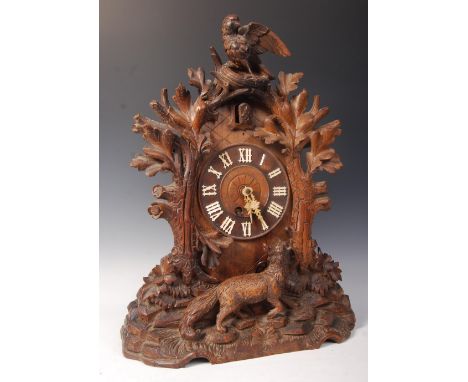 A 19th Century German Black Forest carved oak cased mantel cuckoo clock having carved pediment featuring birds and leaves wit