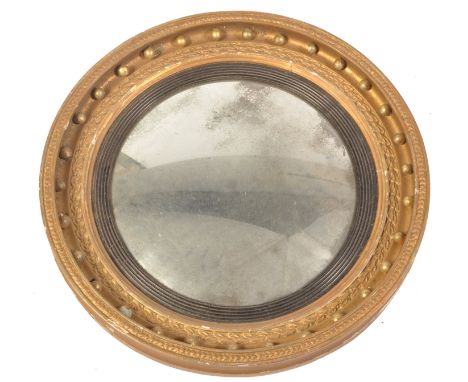 A 19th century Regency giltwood convex wall mirror. Of circular form&nbsp; with ball finial plaster embellishments to the cus