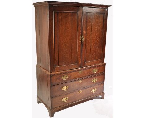 An 18th century, circa 1790, George III country oak linen press. The top with stub cornice over twin fielded panel doors encl