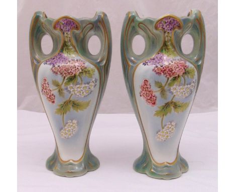 A pair of early 20th century French ceramic vases decorated with flowers and leaves, marks to the bases, 40cm (h)