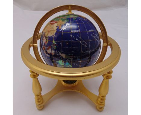 A table top composite globe with compass to the base supported by a brass frame, 25 x 23cm