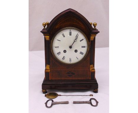 An Edwardian mahogany and satinwood inlaid mantle clock, of architectural form, white enamel dial with Roman numerals, two tr