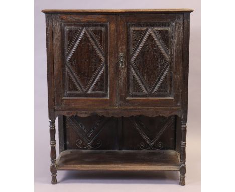 A late 19th/early 20th century small oak side cabinet fitted two shelves enclosed by a pair of panel doors, &amp; on short tu